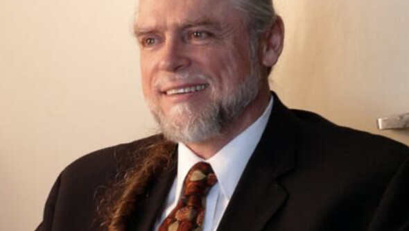 Older white man with beard wearing suit and tie