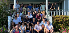 group of smiling people standing on a front porch of a house