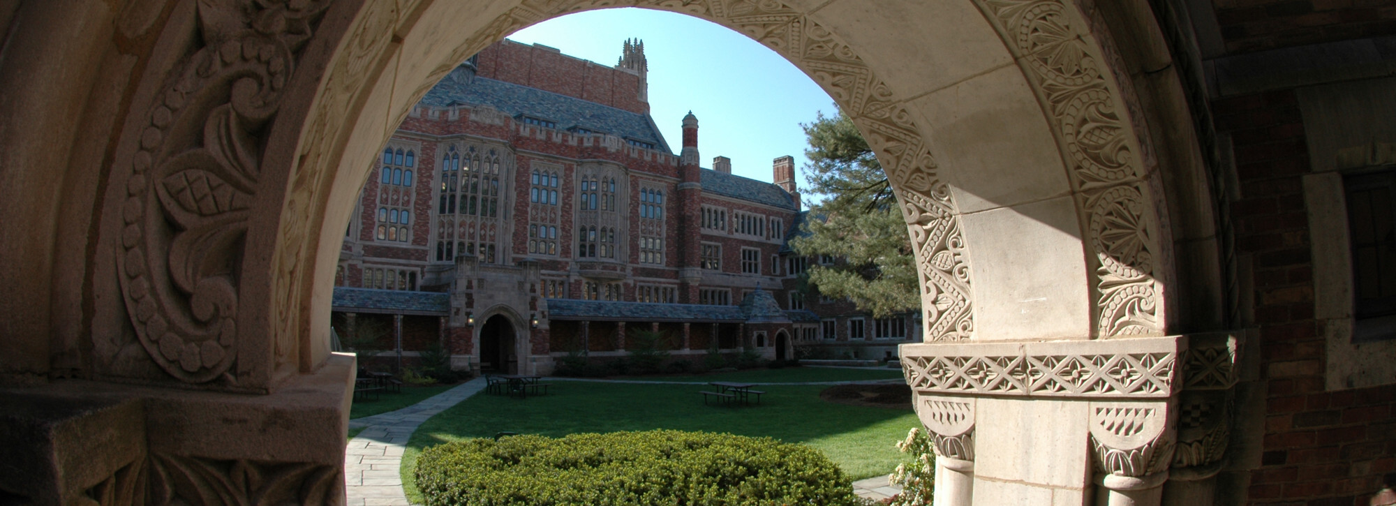 A view of the Sol Goldman courtyard through an arch facing the main Sterling Law building.
